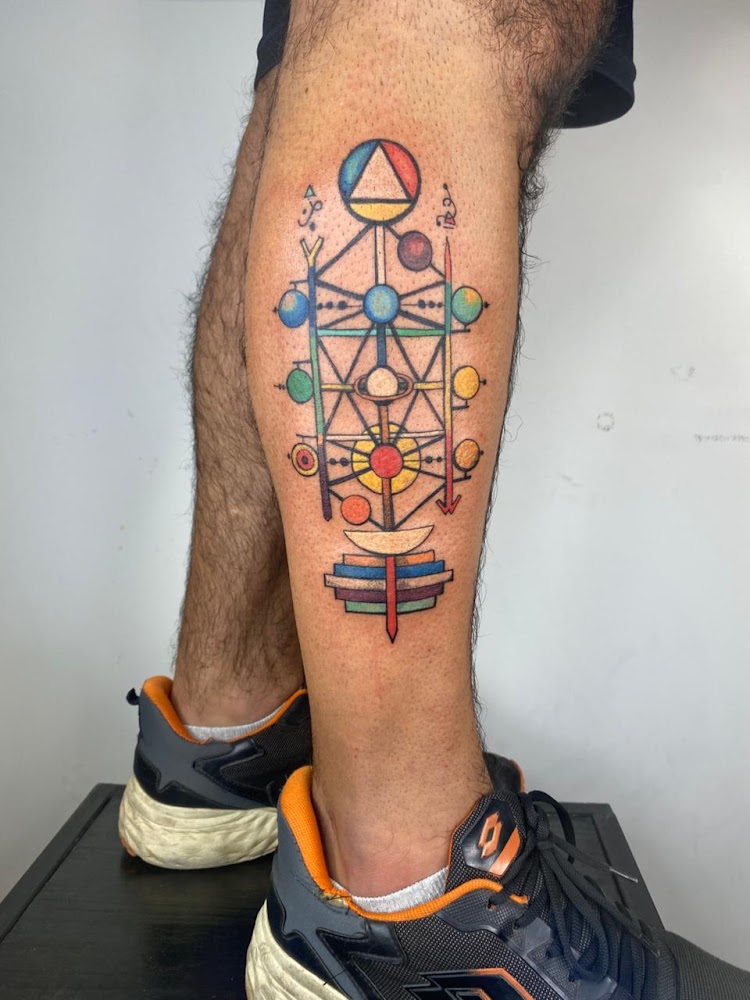 Tatuador en sesión de trabajo con aguja y guantes negros